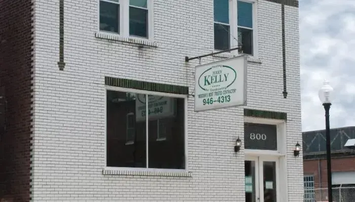 A white brick building with a sign reading “Kelly Realty” above the door and the address number 800 next to the entrance.